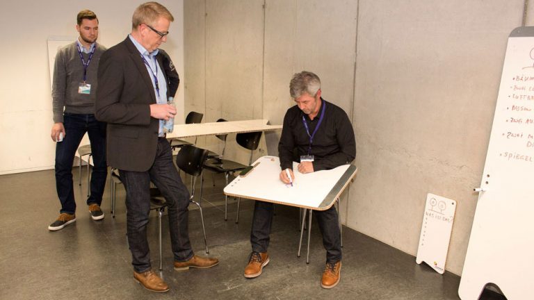 Foto: Zwei Personen schreiben auf einem Whiteboard beim Design-thinking am WUD 2016